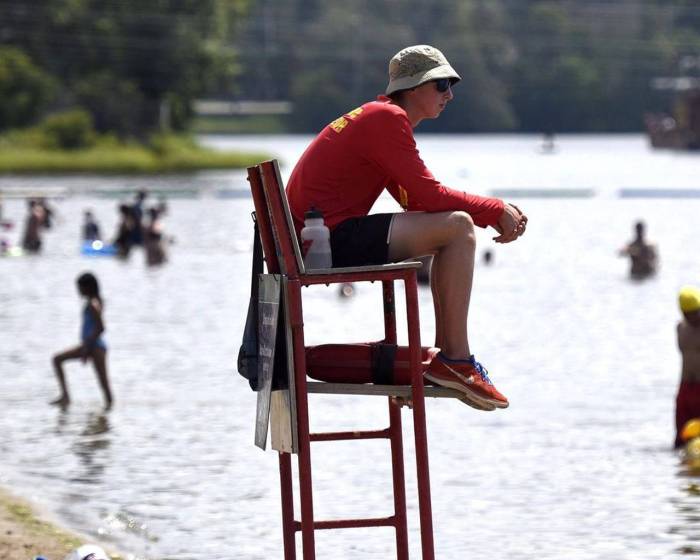 A lifeguard is sitting on a platform